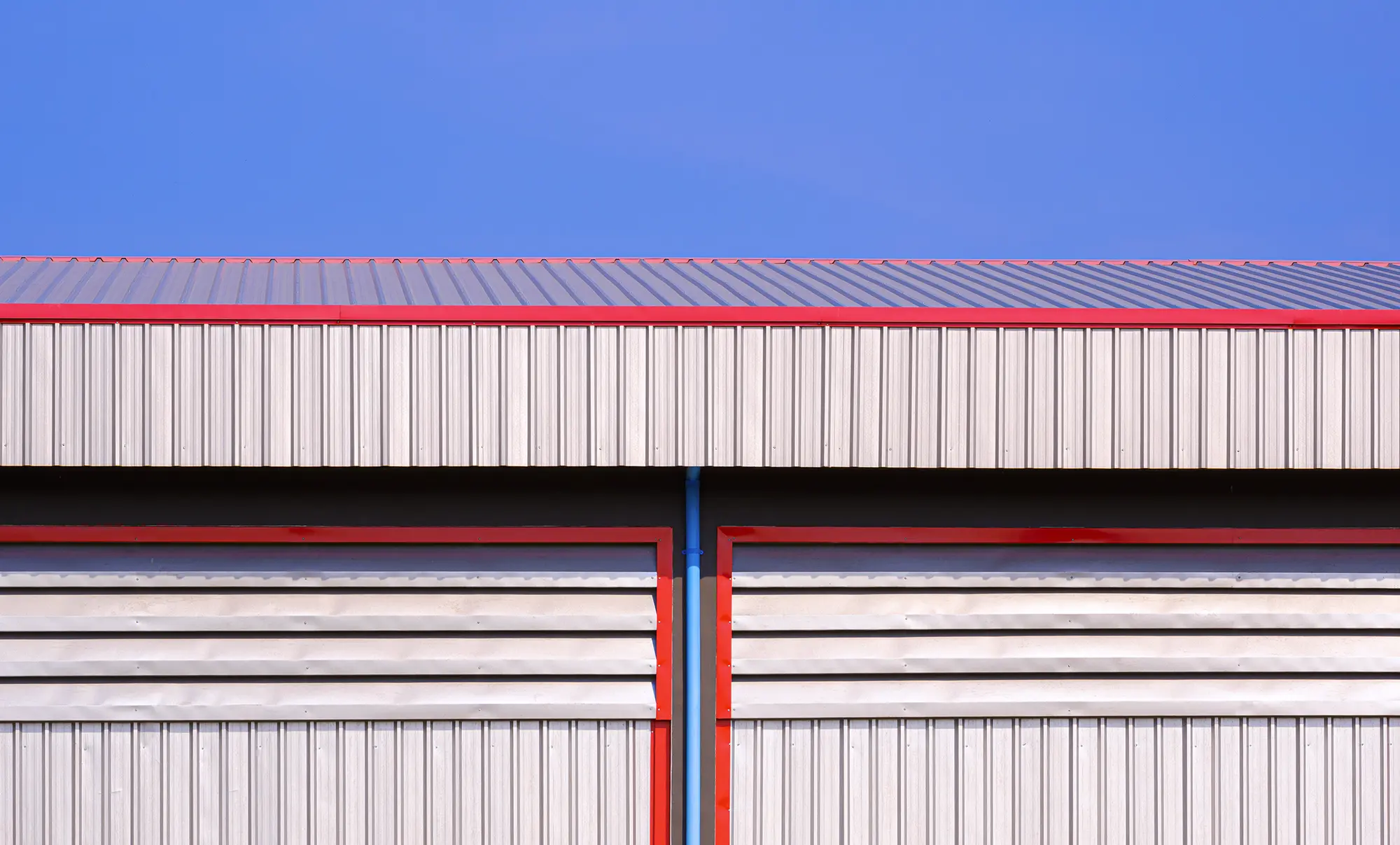 Insulated metal panel envelope with engineered intake louvers and corrugated facade